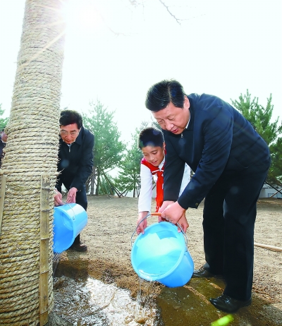 4月2日，党和国家领导人习近平、李克强、张德江、俞正声、刘云山、王岐山、张高丽等来到北京市丰台区永定河畔参加首都义务植树活动。这是习近平同少先队员一起给刚栽下的银杏树浇水。新华社记者